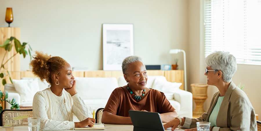 Three women sitting and talking around a table