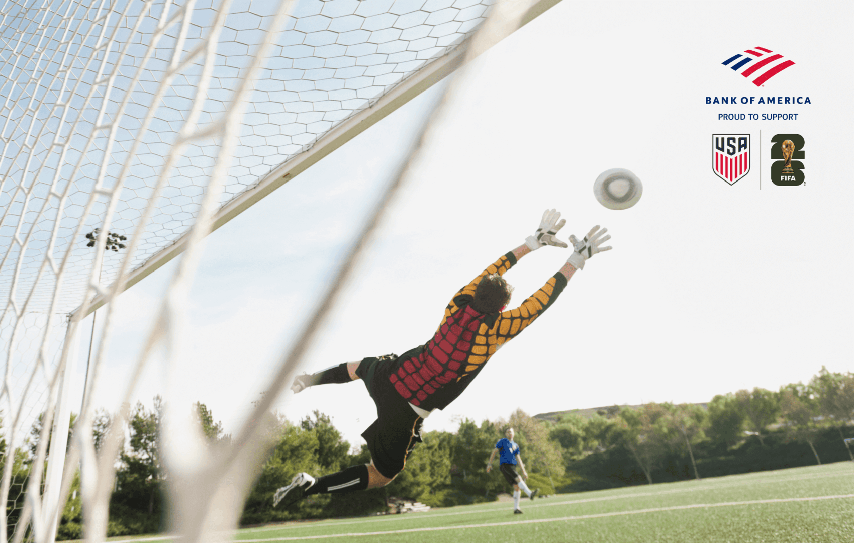 Player saving a goal as the other player kicks the ball while playing soccer