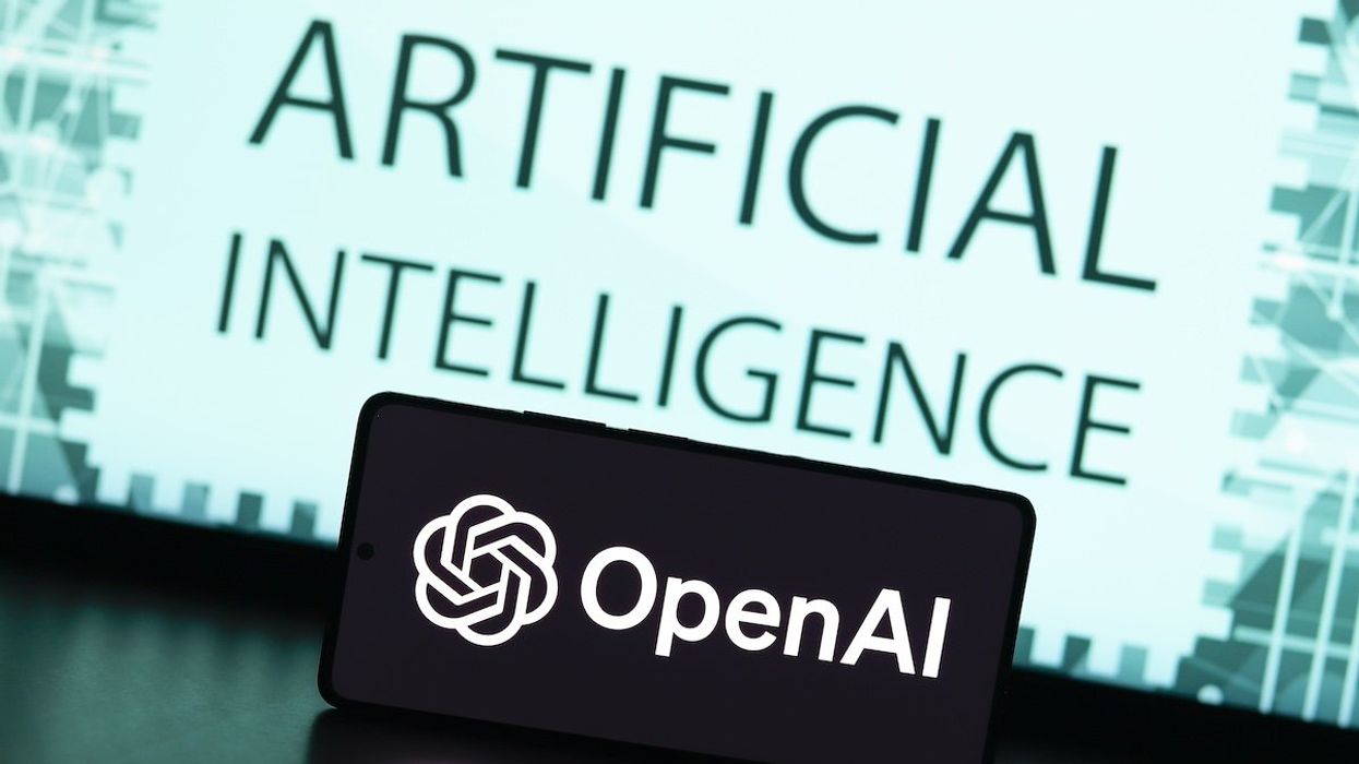 In this photo illustration, the OpenAI logo is displayed on a smartphone screen with the text artificial intelligence in the background.