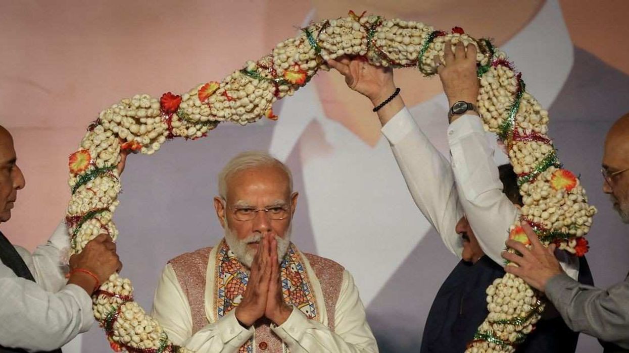 India's Home Minister Amit Shah and India's Defence Minister Rajnath Singh present a garland to Prime Minister Narendra Modi, as Bharatiya Janata Party (BJP) supporters celebrate the Bihar state assembly election results, at the party headquarters in New Delhi, India, November 14, 2025.