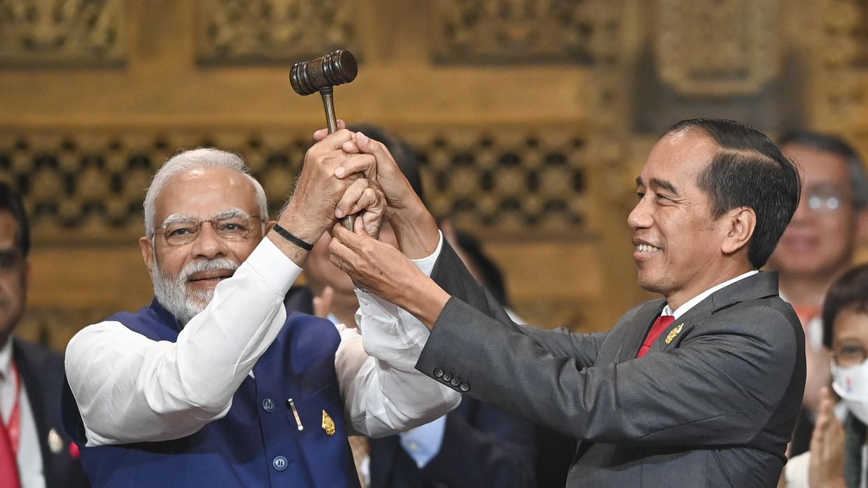 Indonesian President Joko Widodo (R) hands over the G-20 presidency gavel to India's PM Narendra Modi (L) at the G-20 summit in Bali.