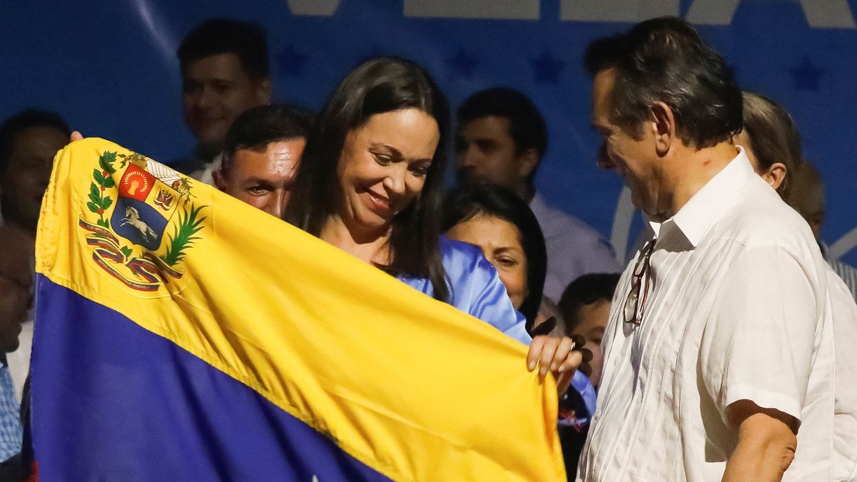 Industrial engineer and former lawmaker Maria Corina Machado holds up a Venezuelan flag as she reacts to the vote count after Venezuelans voted in a primary to choose a unity opposition candidate to face Venezuela's President Nicolas Maduro in his probable re-election bid in 2024, in Caracas, Venezuela October 23, 2023.