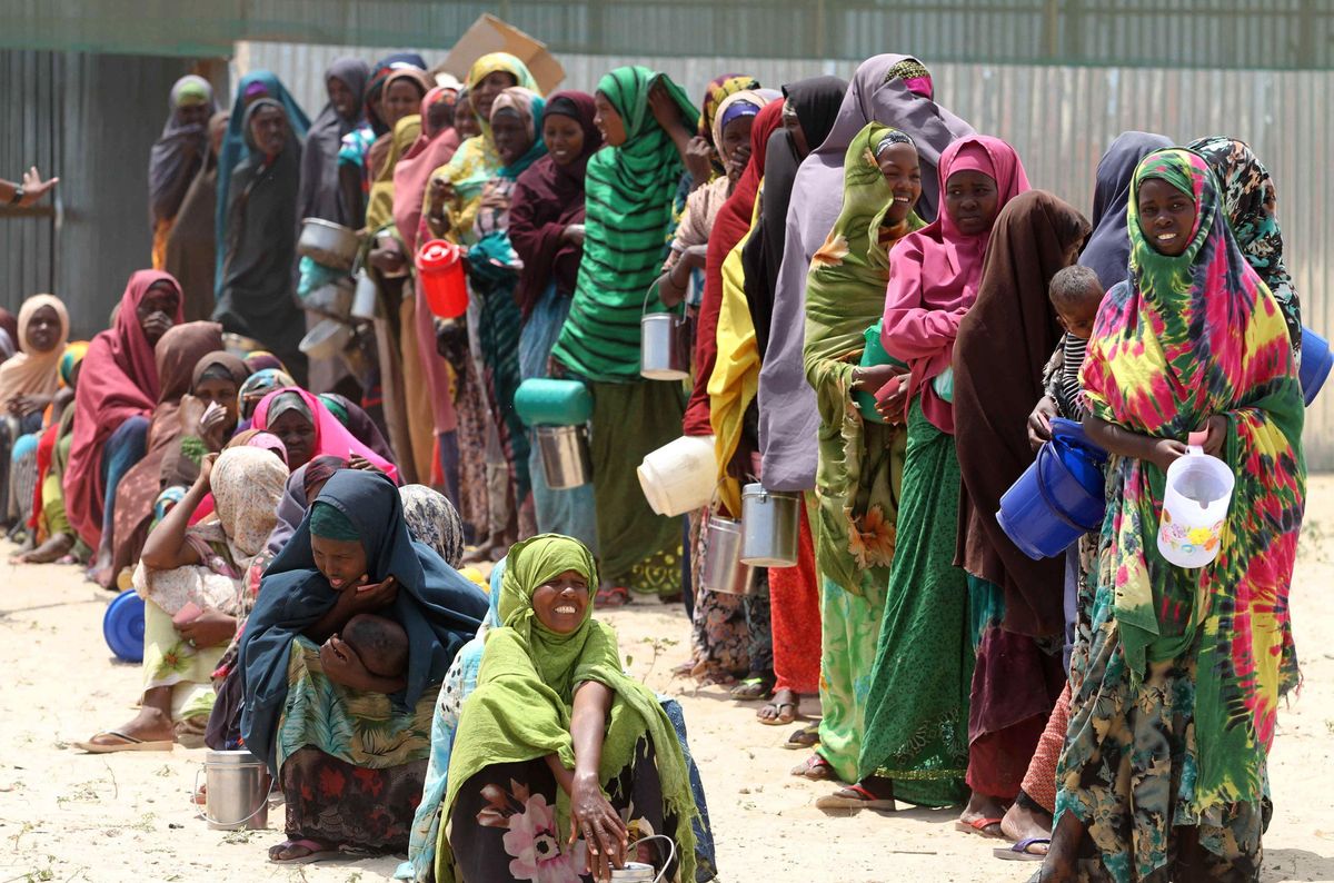 Internally displaced Somali women stand in a queue waiting for relief food to be served south of Mogadishu, September 5, 2011.