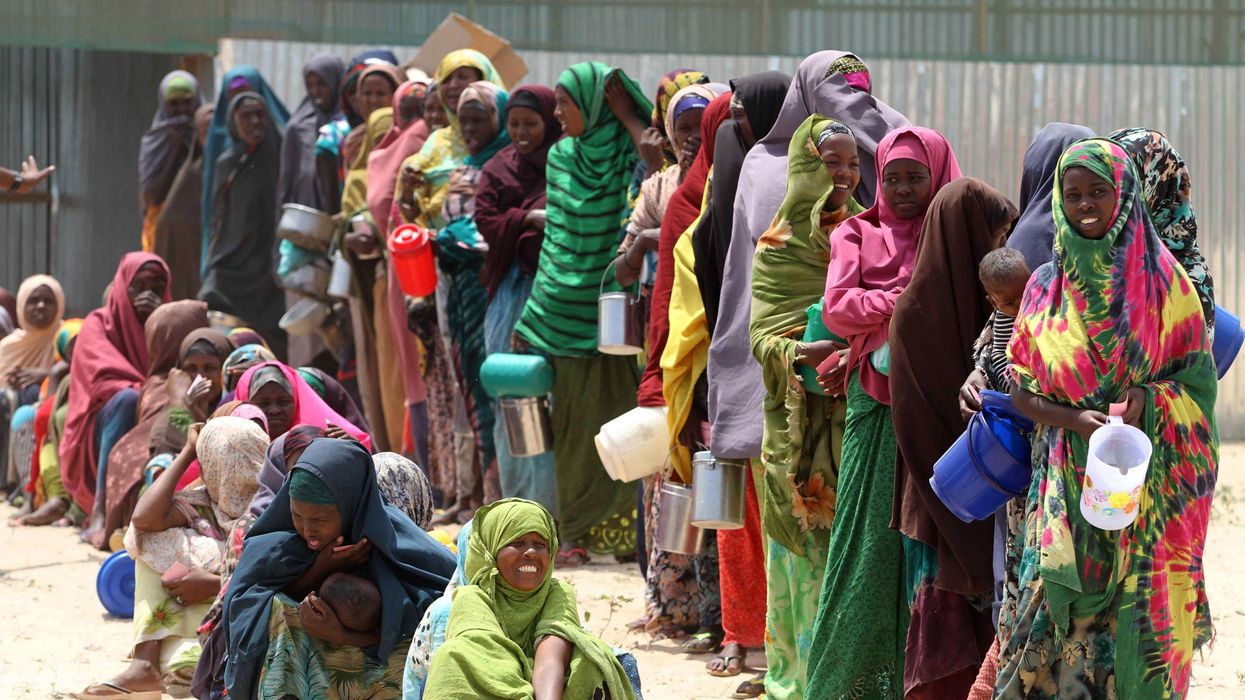 Internally displaced Somali women stand in a queue waiting for relief food to be served south of Mogadishu, September 5, 2011.