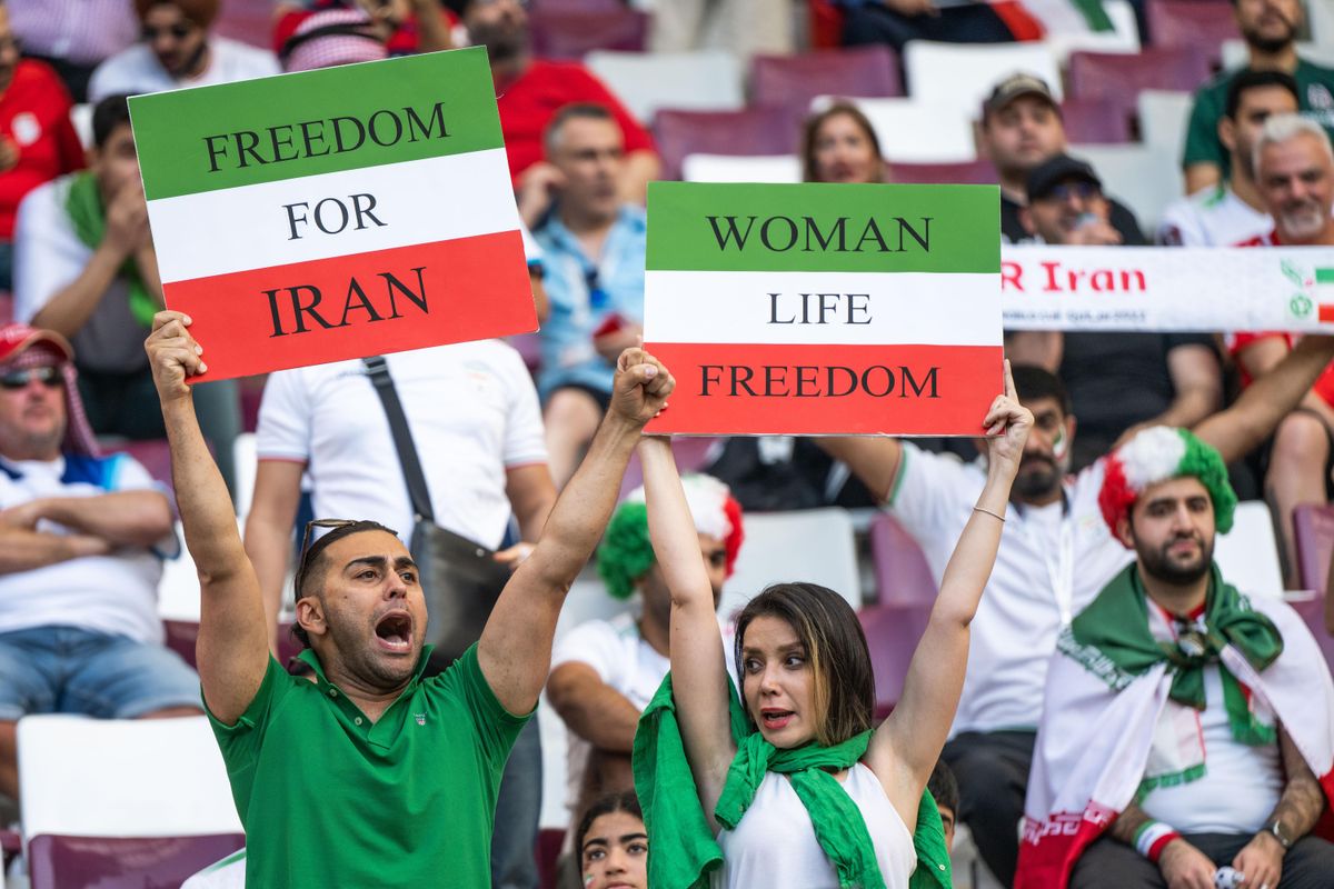 Iran fans hold Freedom For Iran and Women Life Freedom placards before the 2022 FIFA World Cup Group B match against England in Doha, Qatar.