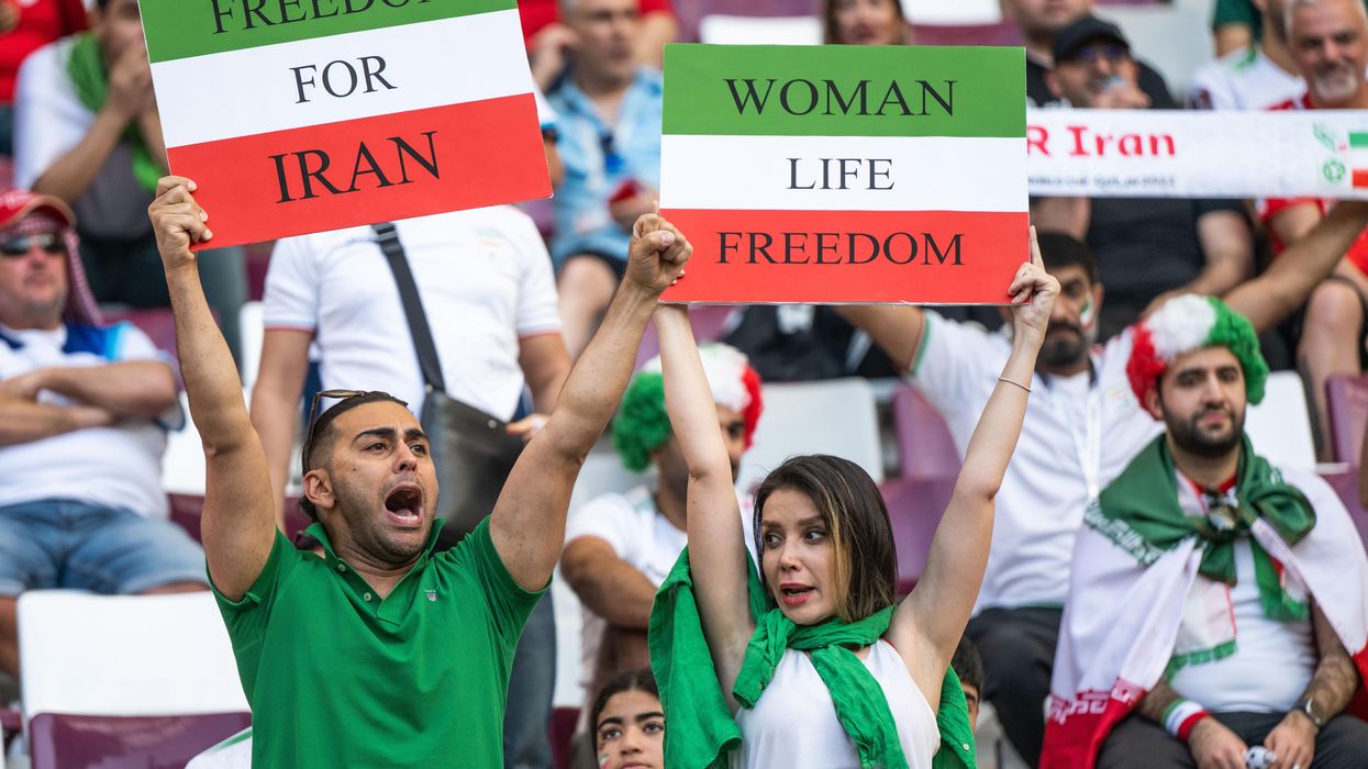 Iran fans hold Freedom For Iran and Women Life Freedom placards before the 2022 FIFA World Cup Group B match against England in Doha, Qatar.