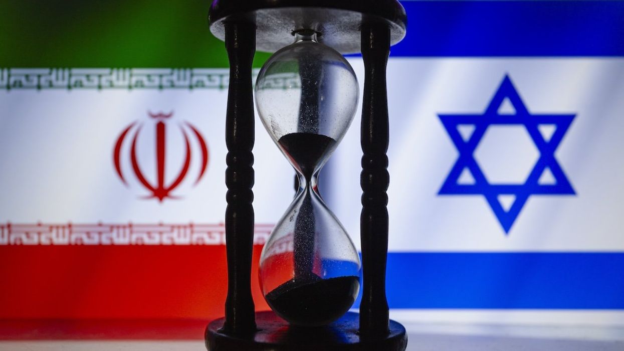 Iranian and Israeli flags behind an hourglass.