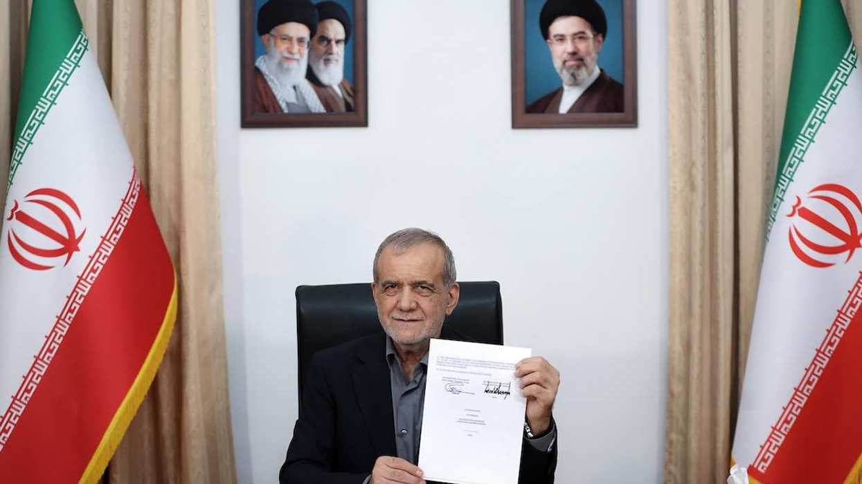 Iranian President Masoud Pezeshkian displays a memorandum of understanding after signing it in Tehran, Iran, on June 18, 2026.