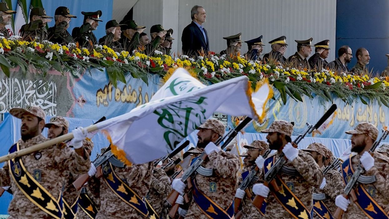 Iranian President Masoud Pezeshkian stands at attention while armed military personnel from the Islamic Revolutionary Guard Corps parade during a military parade commemorating the anniversary of the Iran-Iraq War in Tehran, on Sept. 21, 2024.