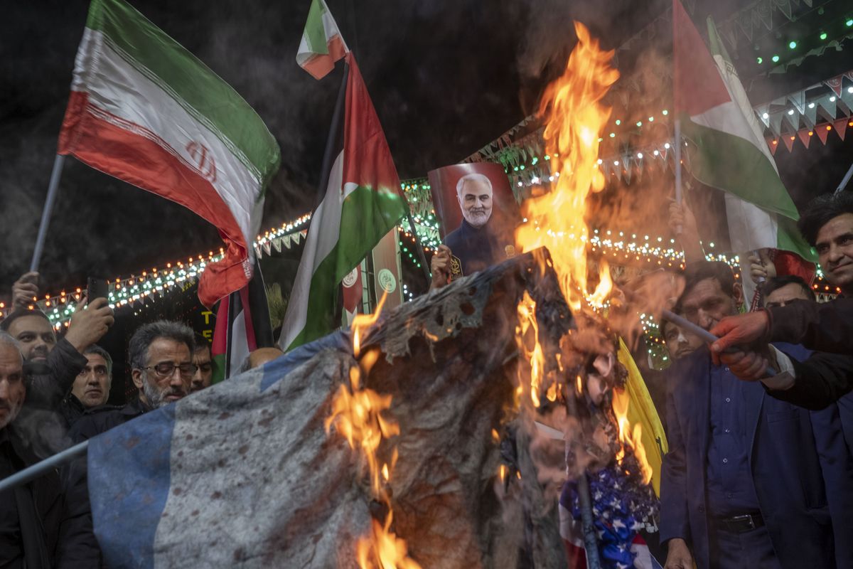 Iranian protesters are burning the U.S. flag and one of them is holding up a portrait of the former commander of the Islamic Revolutionary Guard Corps'.