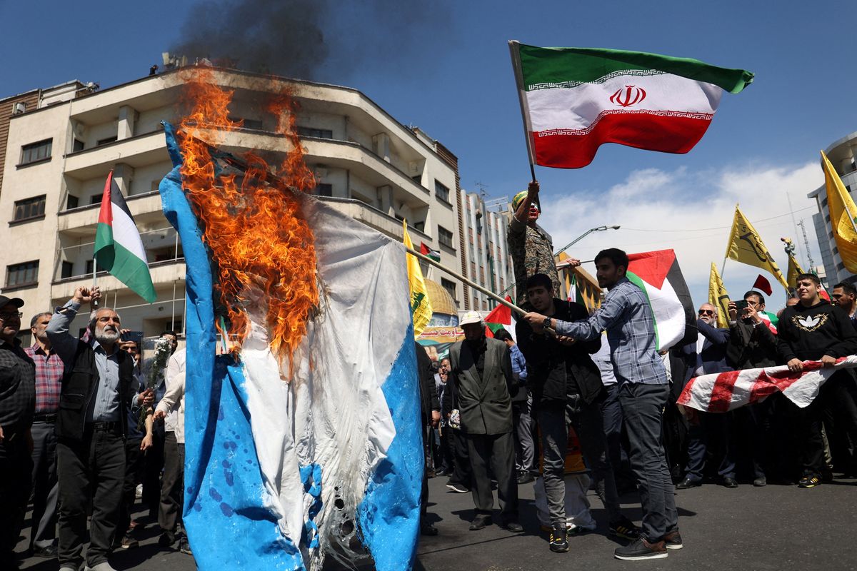 ​ Iranians burn an Israeli flag during a rally marking Quds Day and the funeral of members of the Islamic Revolutionary Guard Corps who were killed in a suspected Israeli airstrike on the Iranian embassy complex in the Syrian capital Damascus, in Tehran, Iran, April 5, 2024. 