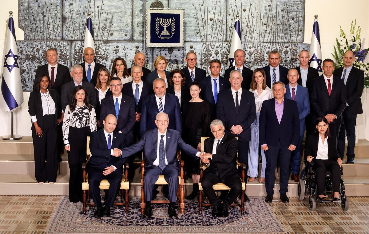 Israel's President Reuven Rivlin sits next to Prime Minister Naftali Bennett as they pose for a group photo together with ministers of the new Israeli government, in Jerusalem June 14, 2021.