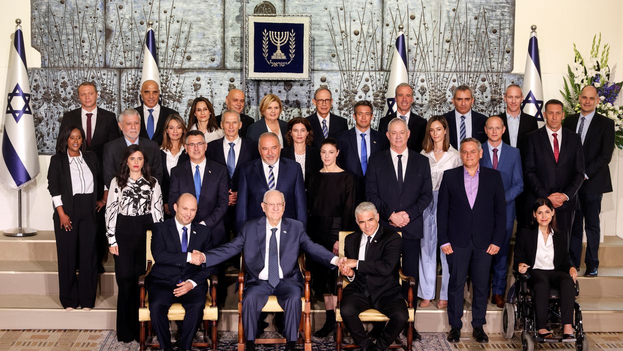 Israel's President Reuven Rivlin sits next to Prime Minister Naftali Bennett as they pose for a group photo together with ministers of the new Israeli government, in Jerusalem June 14, 2021.