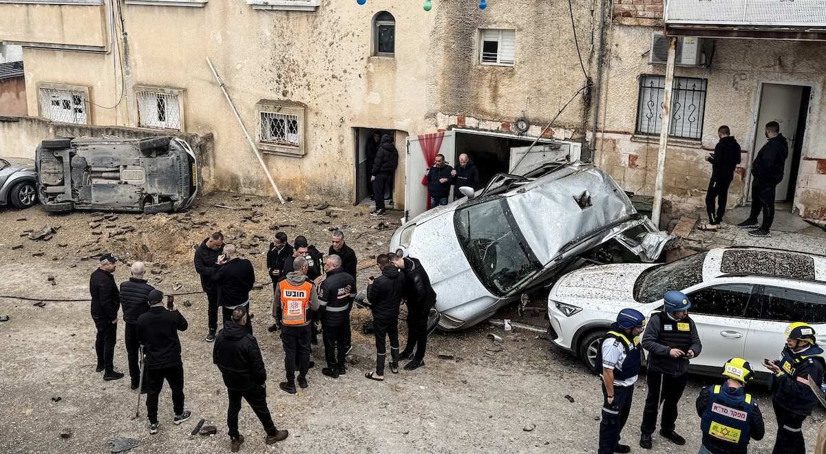 Israeli emergency services, security officials and residents gather at the missile impact site, after Iranian missile barrages were launched at Israel, amid the U.S.-Israel conflict with Iran, in the Arab city of Kafr Qassem in Israel, March 26, 2026. Picture taken using a mobile phone. 