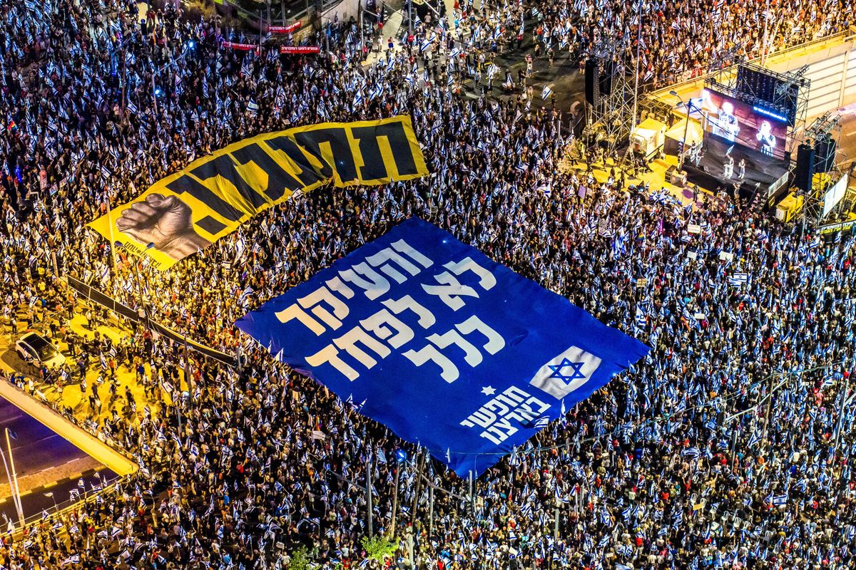 Israeli protesters holding banners with the words in Hebrew "resist" and "the main thing is not to be afraid at all" in a demonstration against the government's judicial overhaul in Tel Aviv.