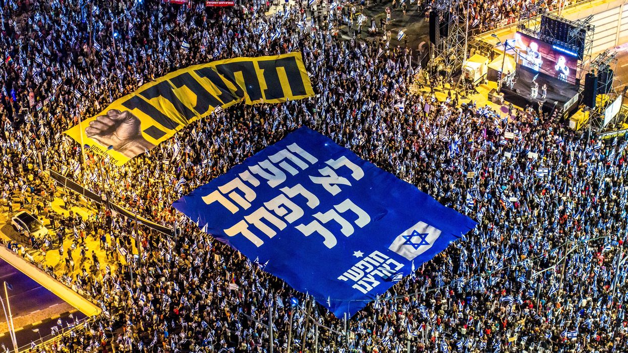 Israeli protesters holding banners with the words in Hebrew "resist" and "the main thing is not to be afraid at all" in a demonstration against the government's judicial overhaul in Tel Aviv.