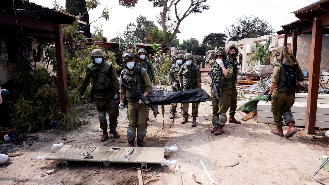 Israeli soldiers carry the body of a victim of an attack by militants from Gaza at Kibbutz Kfar Aza, in southern Israel.