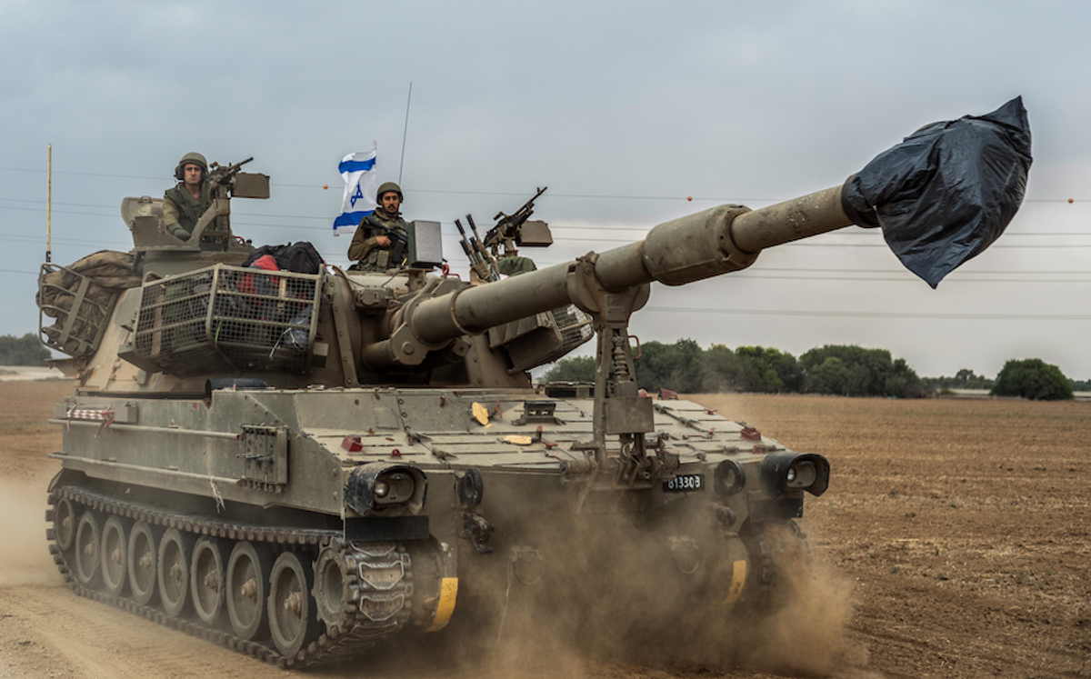 Israeli soldiers on a tank are seen near the Israel-Gaza border on Monday, Oct. 9, 2023.