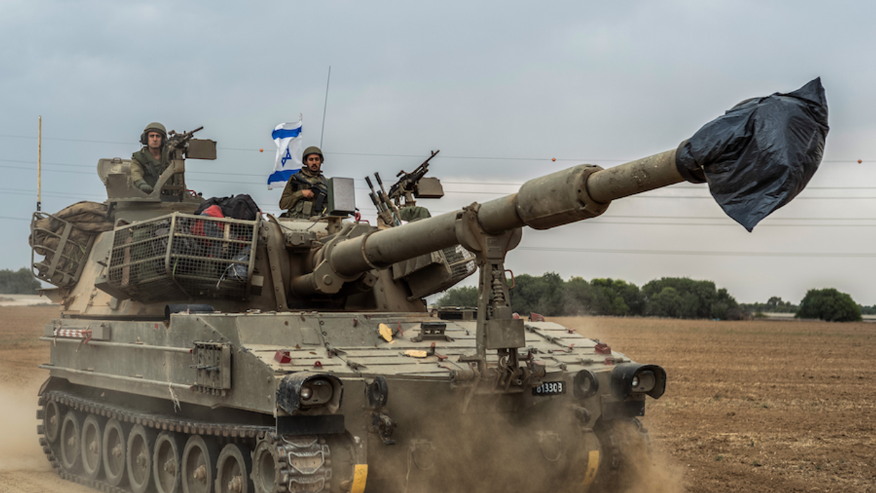 Israeli soldiers on a tank are seen near the Israel-Gaza border on Monday, Oct. 9, 2023.