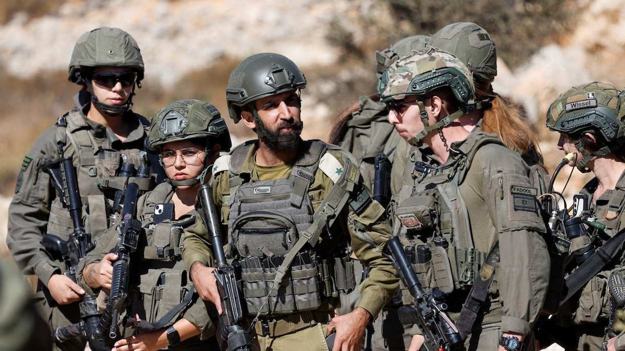 Israeli soldiers stand guard as they deny access to Palestinian farmers to harvest olives, in Burqa near Ramallah in the Israeli-occupied West Bank October 20, 2024.