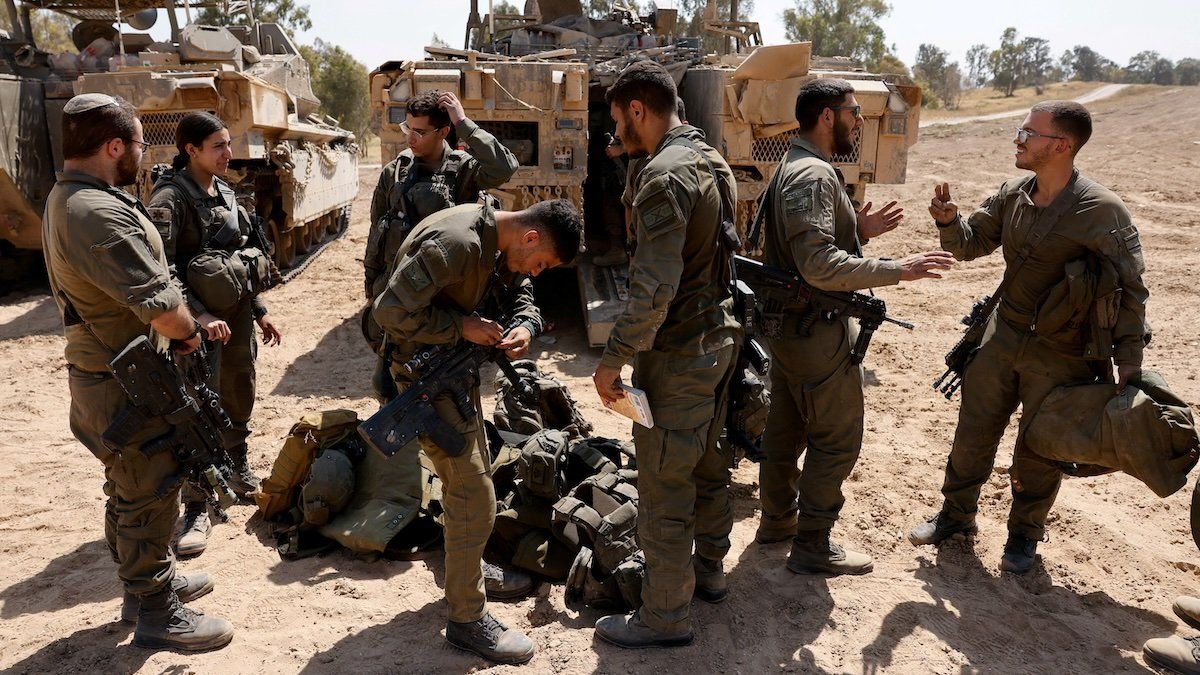 Israeli soldiers stand next to military vehicles, near the Israel-Gaza border, amid the ongoing conflict between Israel and the Palestinian Islamist group Hamas, in Israel, April 15, 2024. 