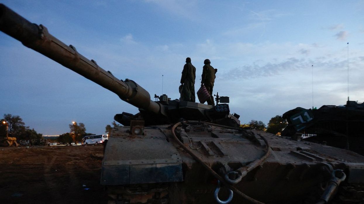 Israeli soldiers stand on an Israeli tank near the Israel-Gaza border, amid the temporary truce between Hamas and Israel, in southern Israel, November 28, 2023.