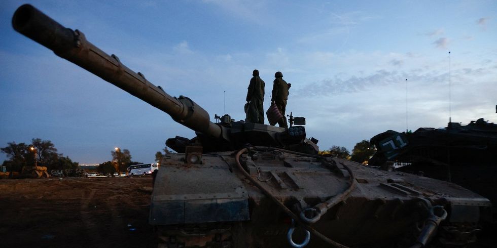Israeli soldiers stand on an Israeli tank near the Israel-Gaza border, amid the temporary truce between Hamas and Israel, in southern Israel, November 28, 2023.
