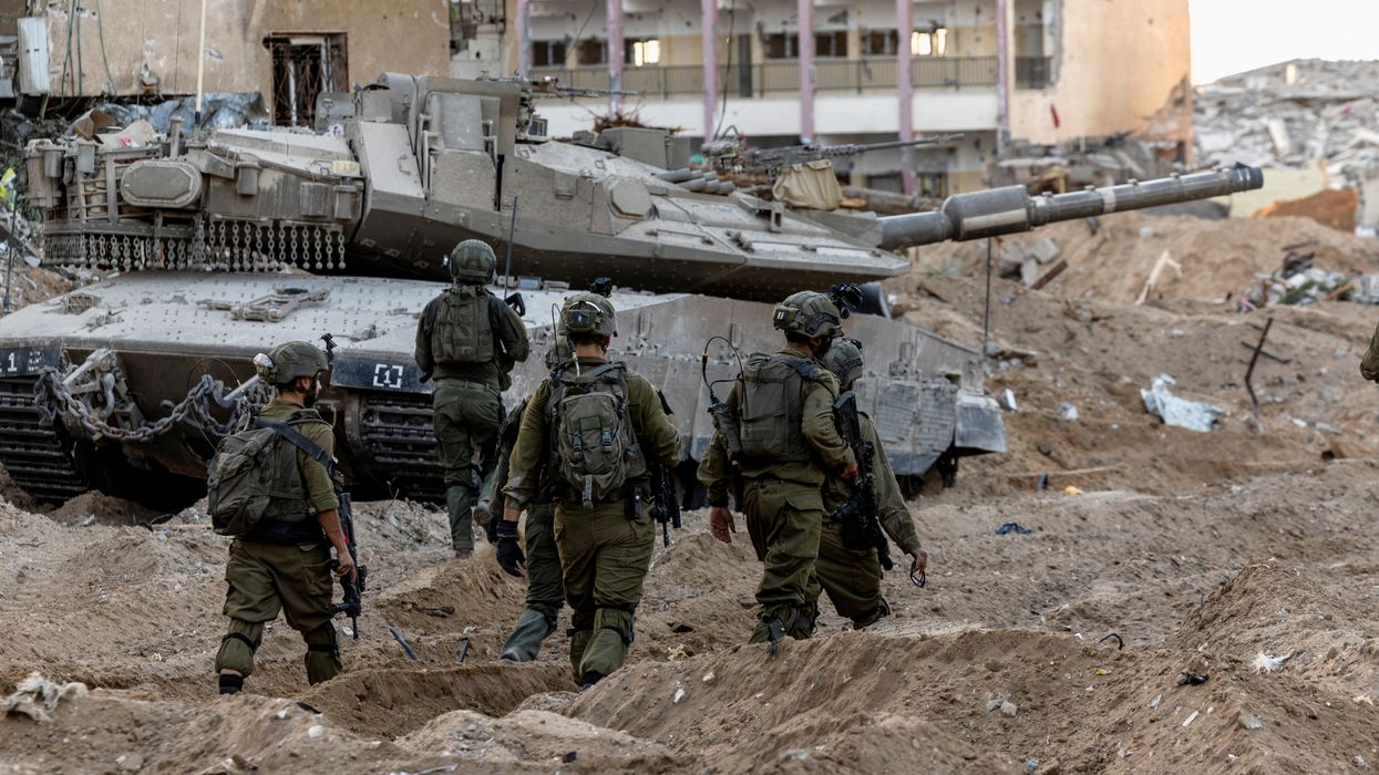 Israeli soldiers walk through rubble, amid the ongoing ground invasion against Palestinian Islamist group Hamas in the northern Gaza Strip, November 8, 2023.