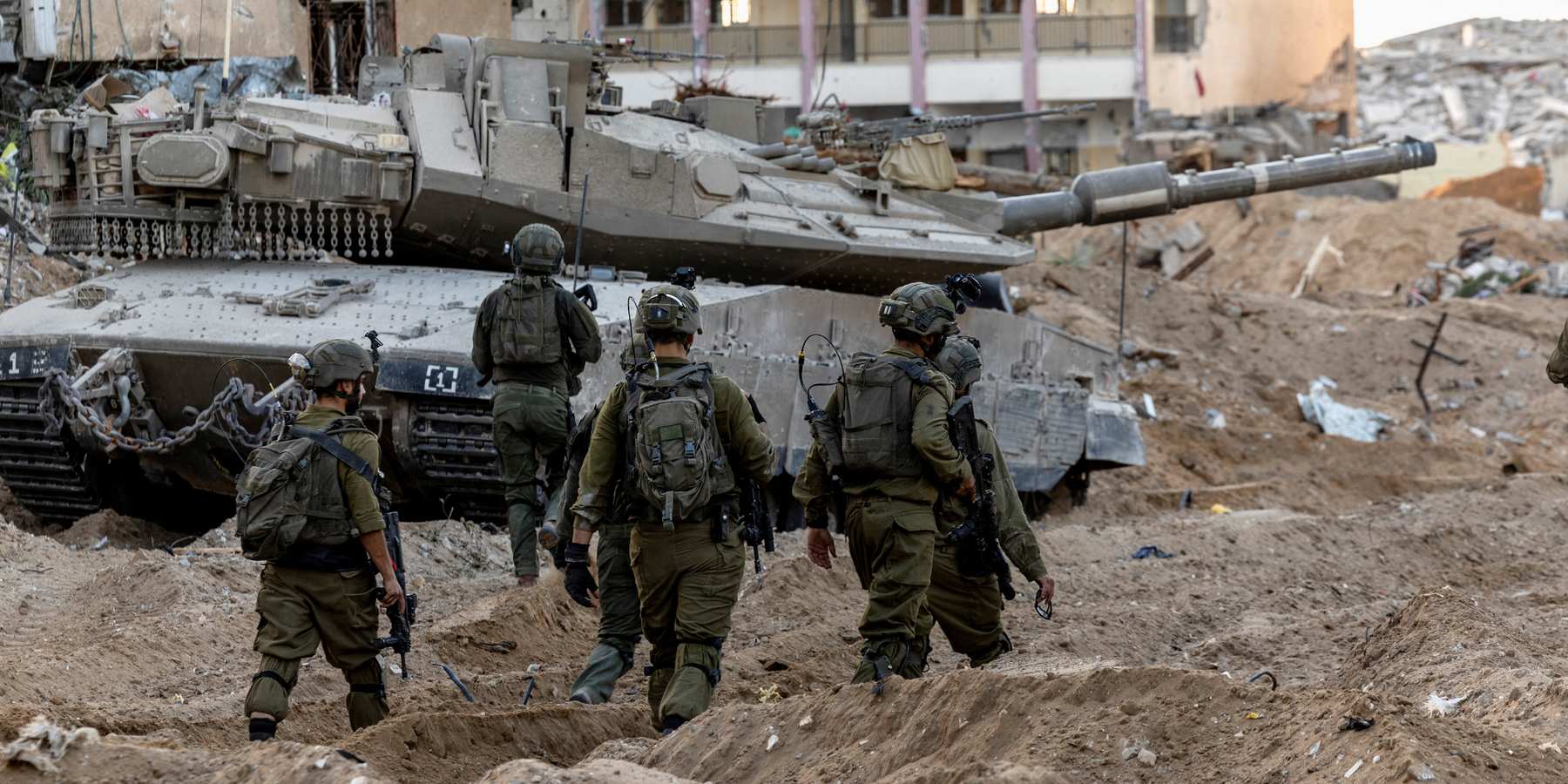 Israeli soldiers walk through rubble, amid the ongoing ground invasion against Palestinian Islamist group Hamas in the northern Gaza Strip, November 8, 2023.