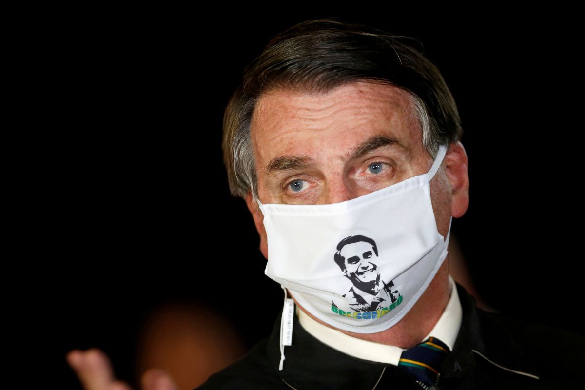 Jair Bolsonaro wears a mask with his image
