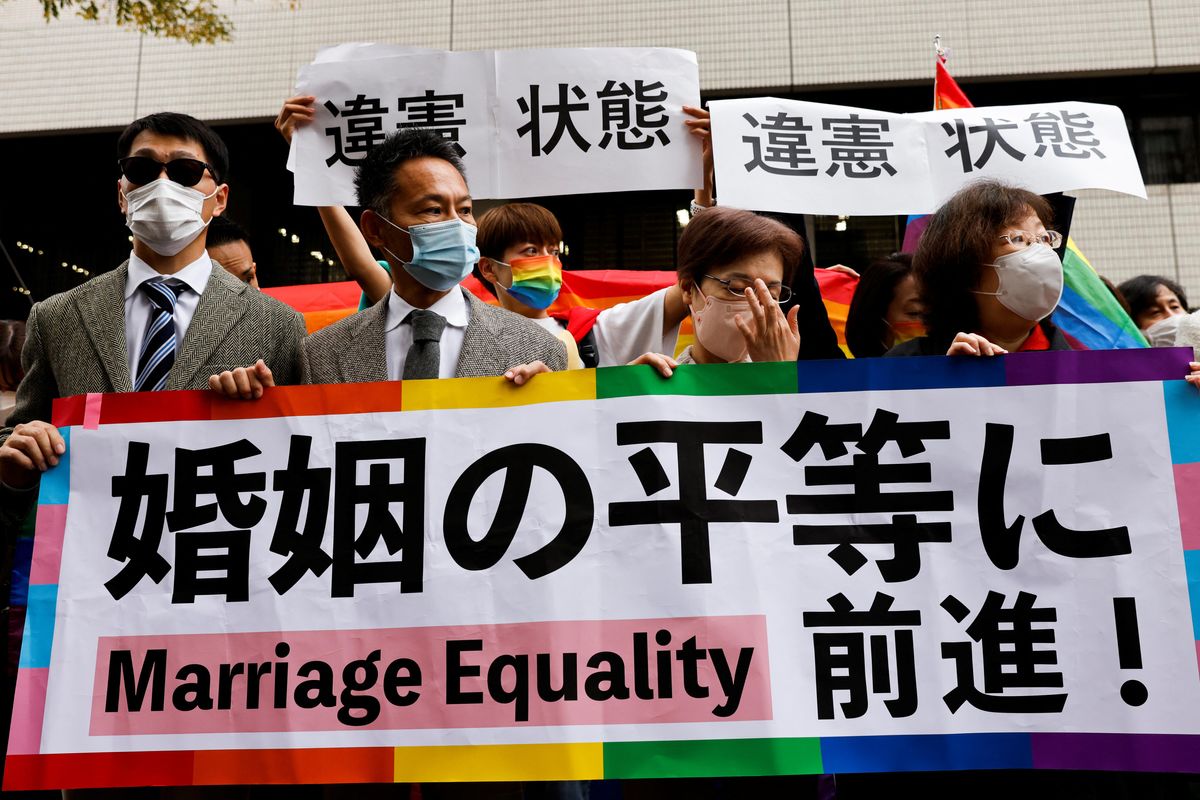 Japanese plaintiffs hold placards reading "A step towards Marriage Equality" outside the court after hearing the ruling on same-sex marriage in Tokyo.