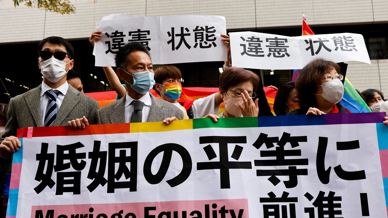 Japanese plaintiffs hold placards reading "A step towards Marriage Equality" outside the court after hearing the ruling on same-sex marriage in Tokyo.