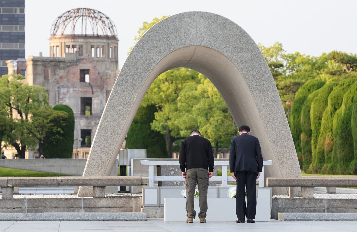 Japanese PM Fumio Kishida (R) and Ukraine's President Volodymyr Zelenskyy bow after laying a bouquet of flowers at the Cenotaph for the Victims of the Atomic Bomb at the Hiroshima Peace Memorial Park.