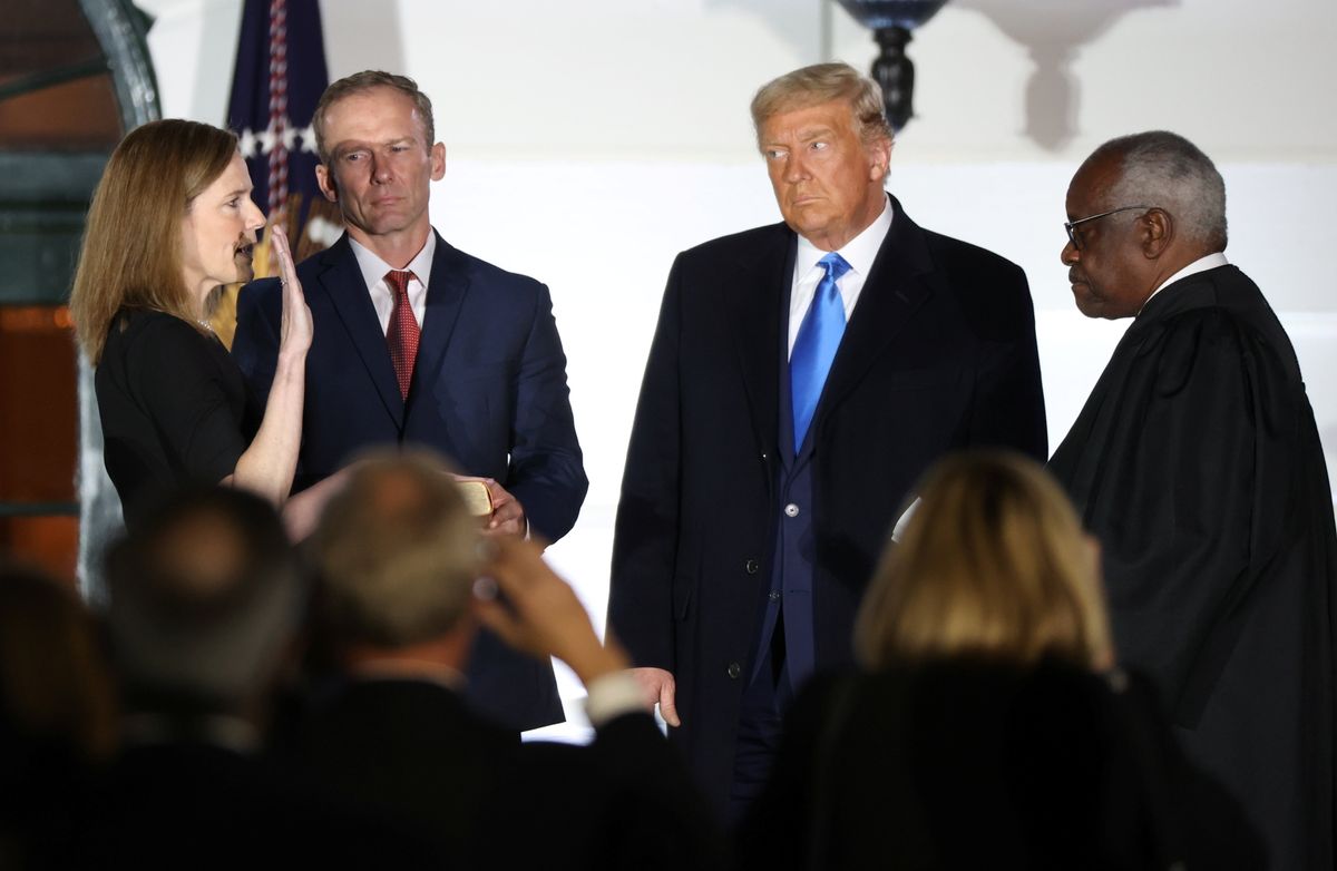 Judge Amy Coney Barrett is sworn in as an associate justice of the U.S. Supreme Court by Supreme Court Justice Clarence Thomas as her husband Jesse Barrett and President Donald Trump watch on the South Lawn of the White House in Washington, U.S., October 26, 2020