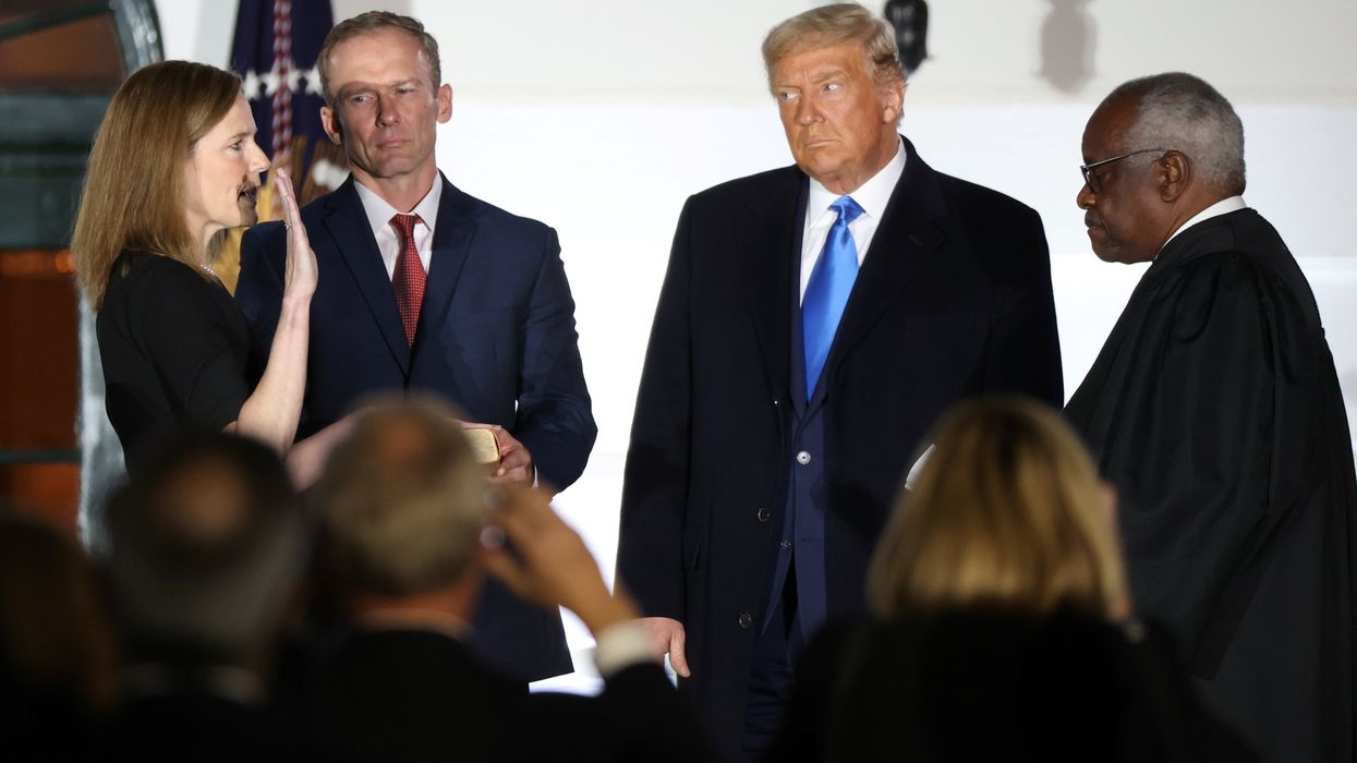 Judge Amy Coney Barrett is sworn in as an associate justice of the U.S. Supreme Court by Supreme Court Justice Clarence Thomas as her husband Jesse Barrett and President Donald Trump watch on the South Lawn of the White House in Washington, U.S., October 26, 2020
