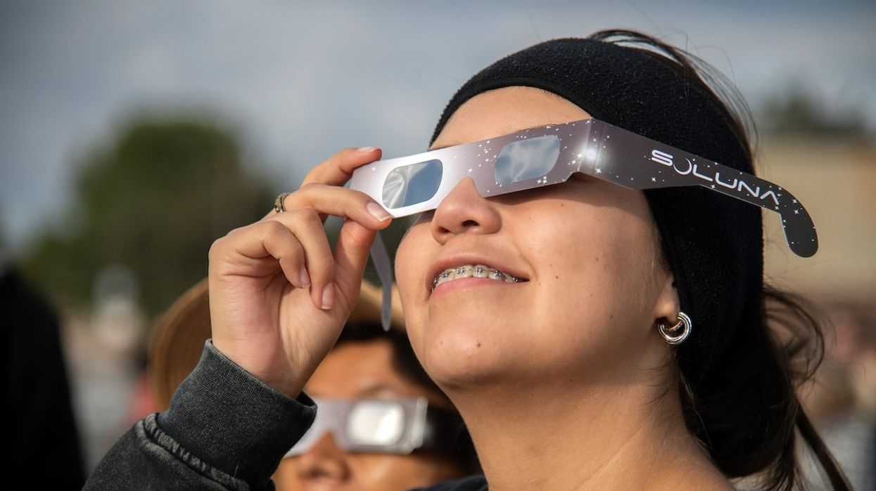 Laura Luciano of Stockton looks at the solar eclipse looks through special glasses during a watch party held by the Delta College Physics-Math-Computer Sciences Club and the the Stockton Astronomical Society on the campus of San Joaquin Delta College in Stockton on Oct. 14, 2023.