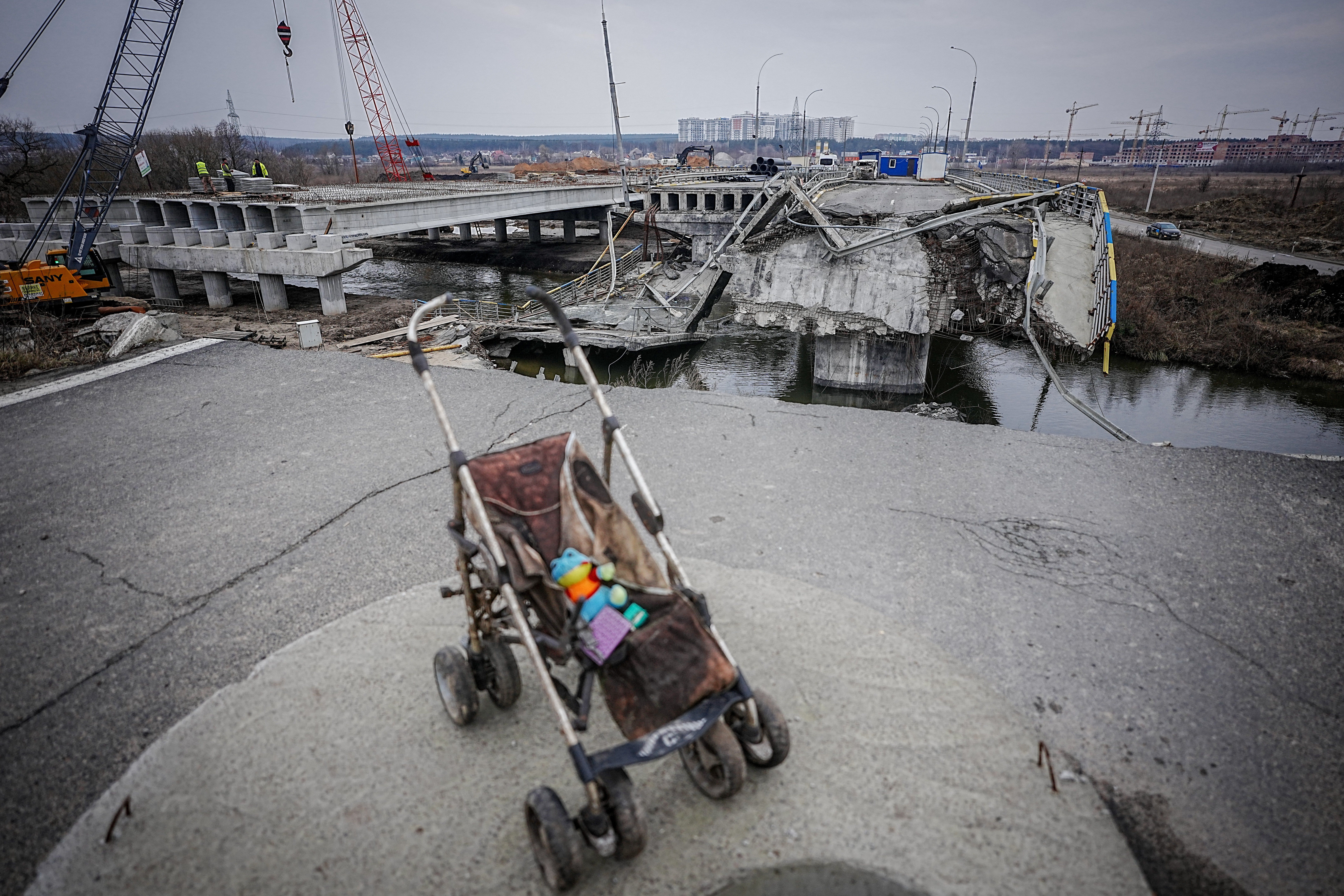 A baby carriage stands on the bridge destroyed during the war on the arterial road from Irpin near Kyiv. 