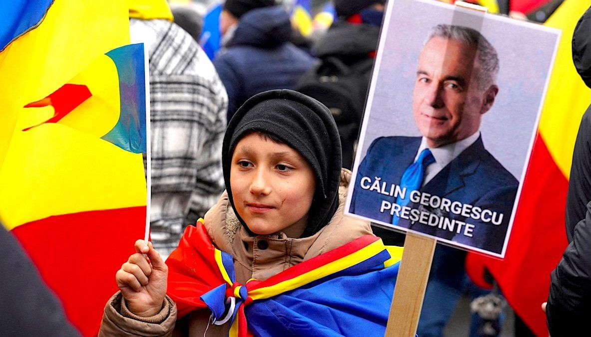 A boy holds a sign reading "Calin Georgescu President" during an anti-government rally in Bucharest, Romania. 