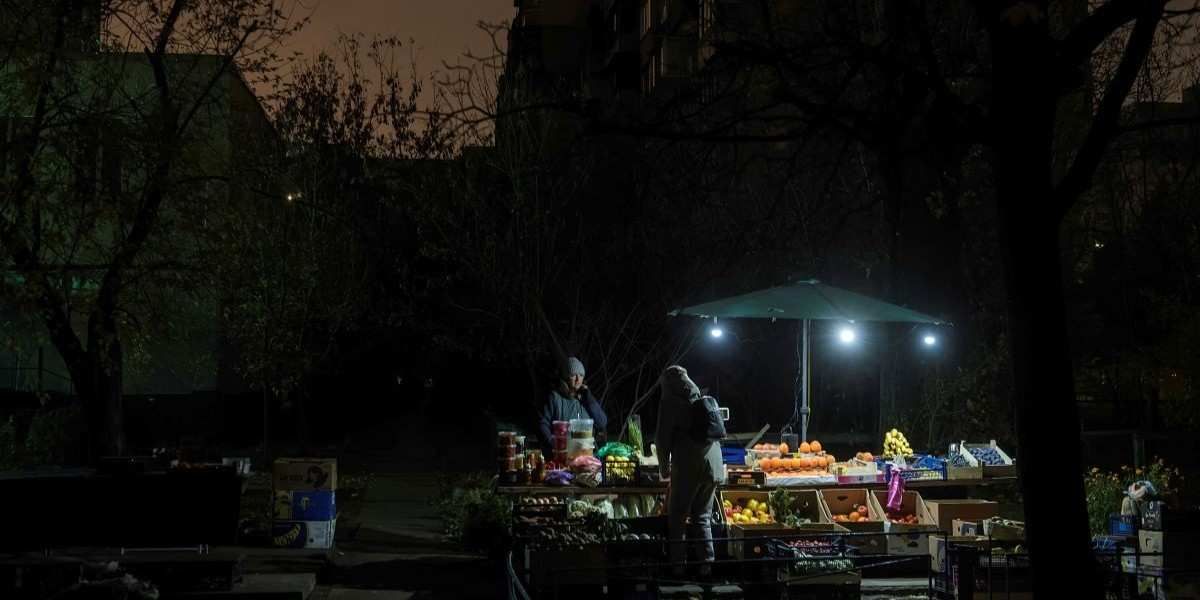 ​A fruit and vegetable stall is lit by small lamps during a blackout in a residential neighborhood in Kyiv, Ukraine, on November 6, 2025, after massive Russian attacks on Ukraine's energy infrastructure in October. 