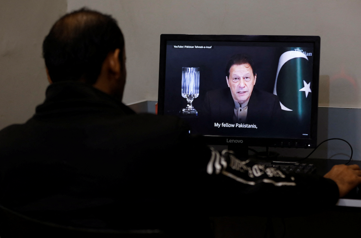 ​A man views a computer screen displaying an AI-crafted speech of former Prime Minister Imran Khan. 