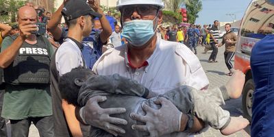A medic carries a Palestinian boy killed in an Israeli strike near a hospital in Khan Younis in the southern Gaza Strip on Oct. 24, 2023.