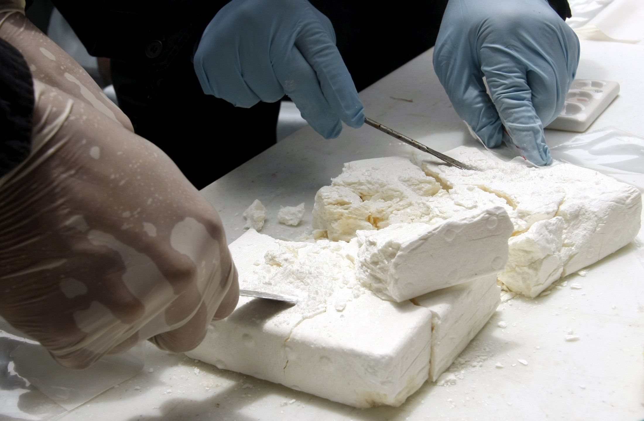 A member of Colombia's Navy checks cocaine seized in the Gulf of Morrosquillo