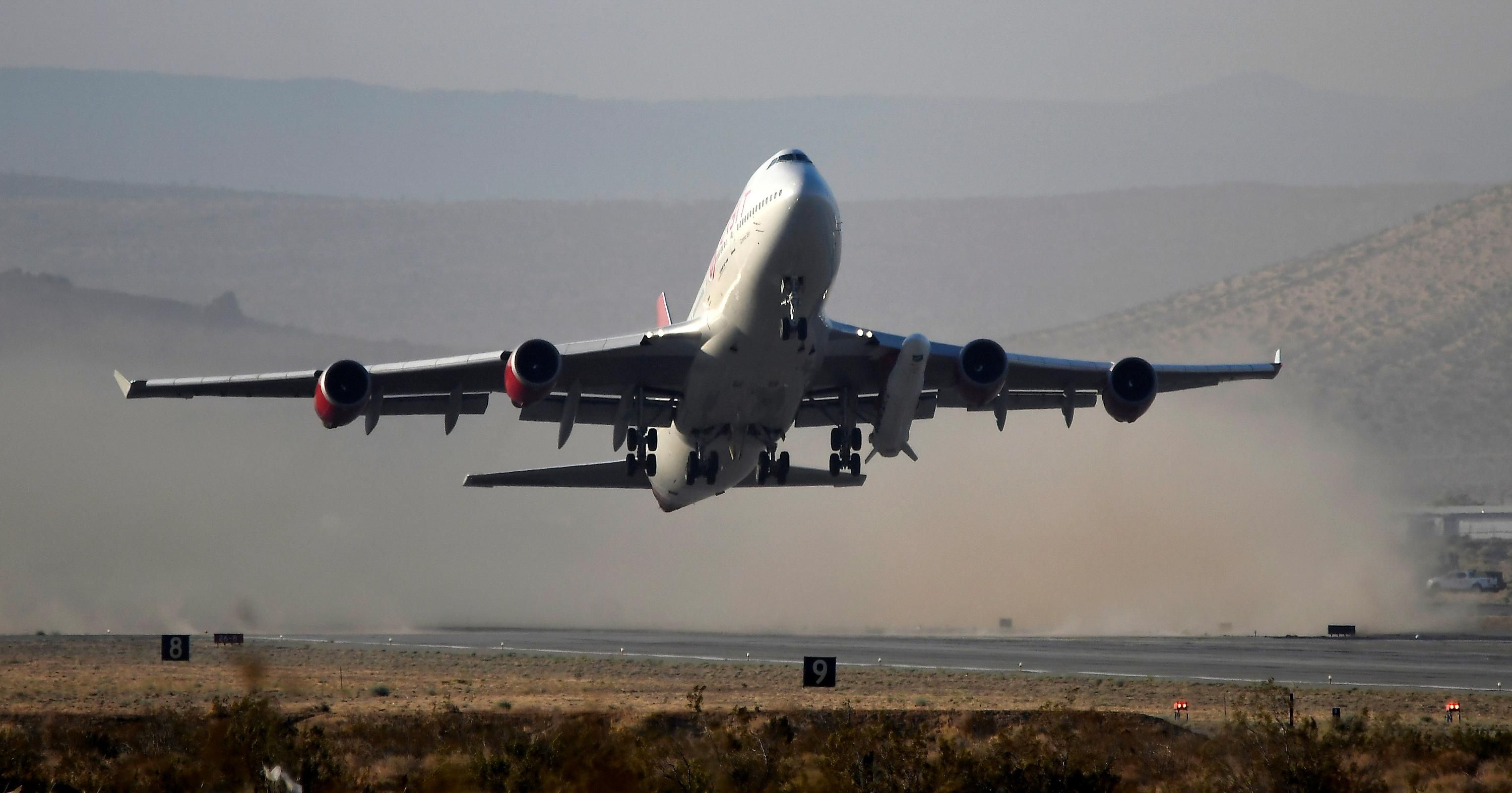 A modified Boeing 747 takes off carrying Virgin Orbit's LauncherOne rocket, in Mojave, California