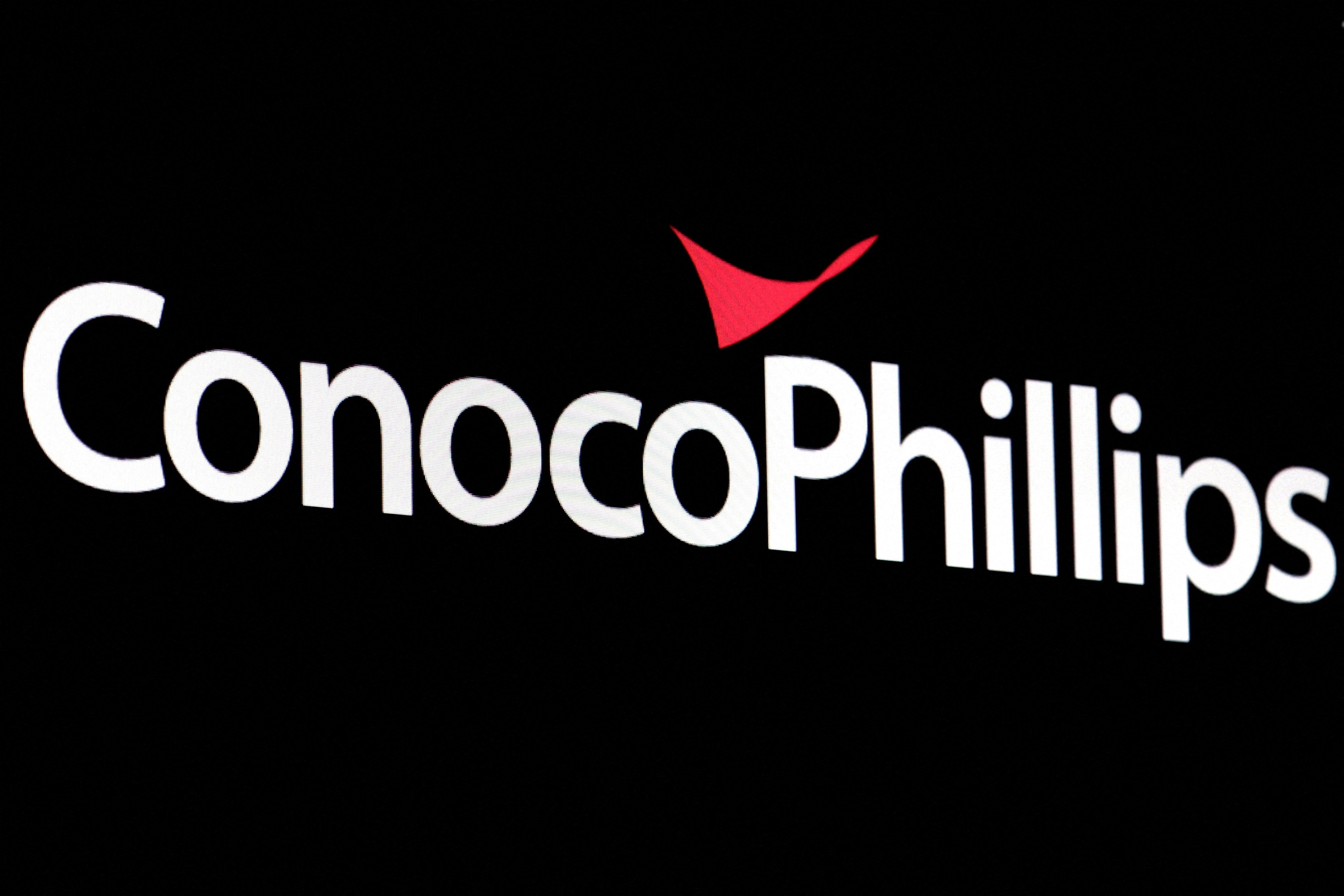A screen displays the logo for ConocoPhillips on the floor of the New York Stock Exchange.