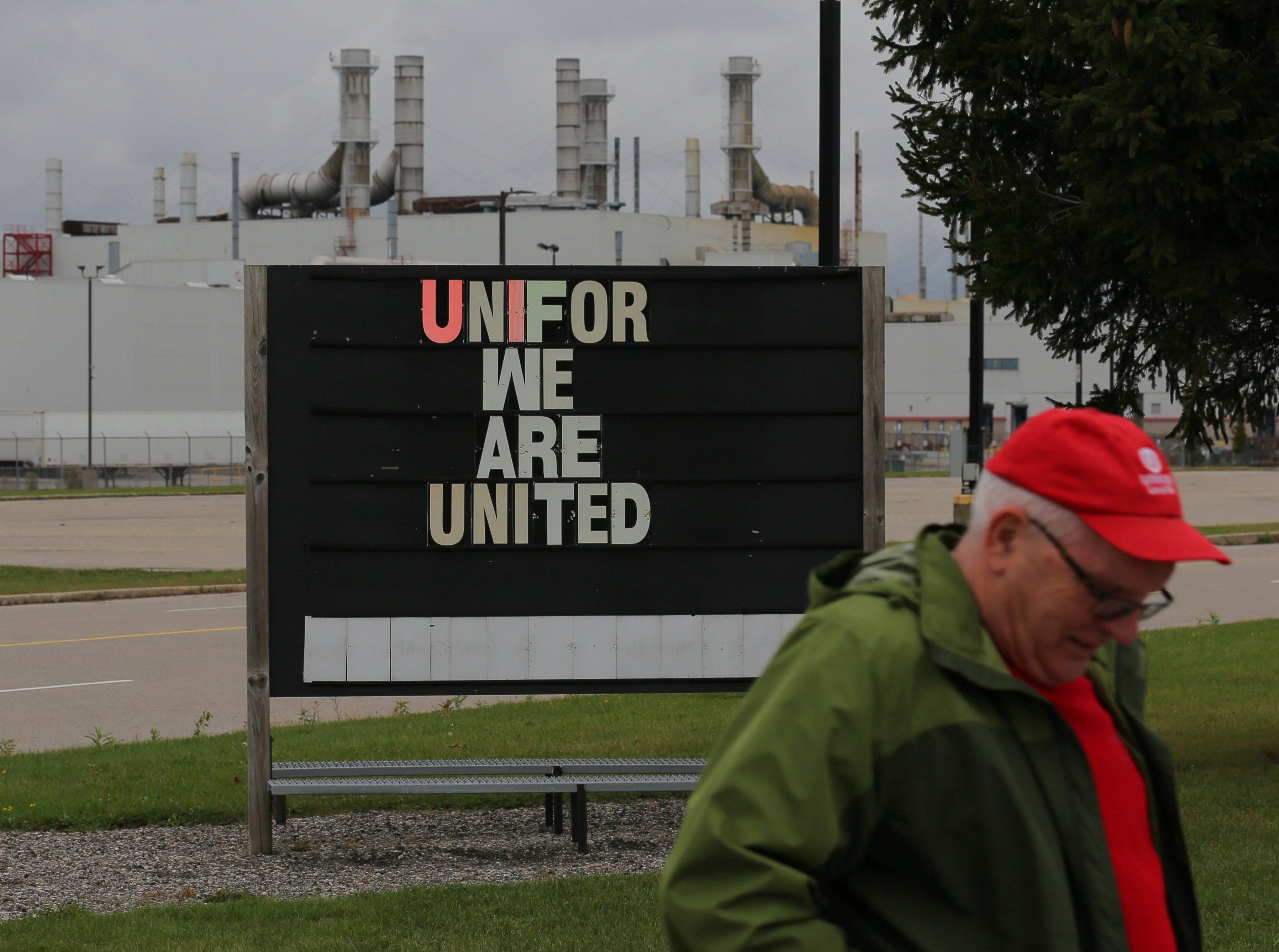 A striking member of the union Unifor walks to a picket line