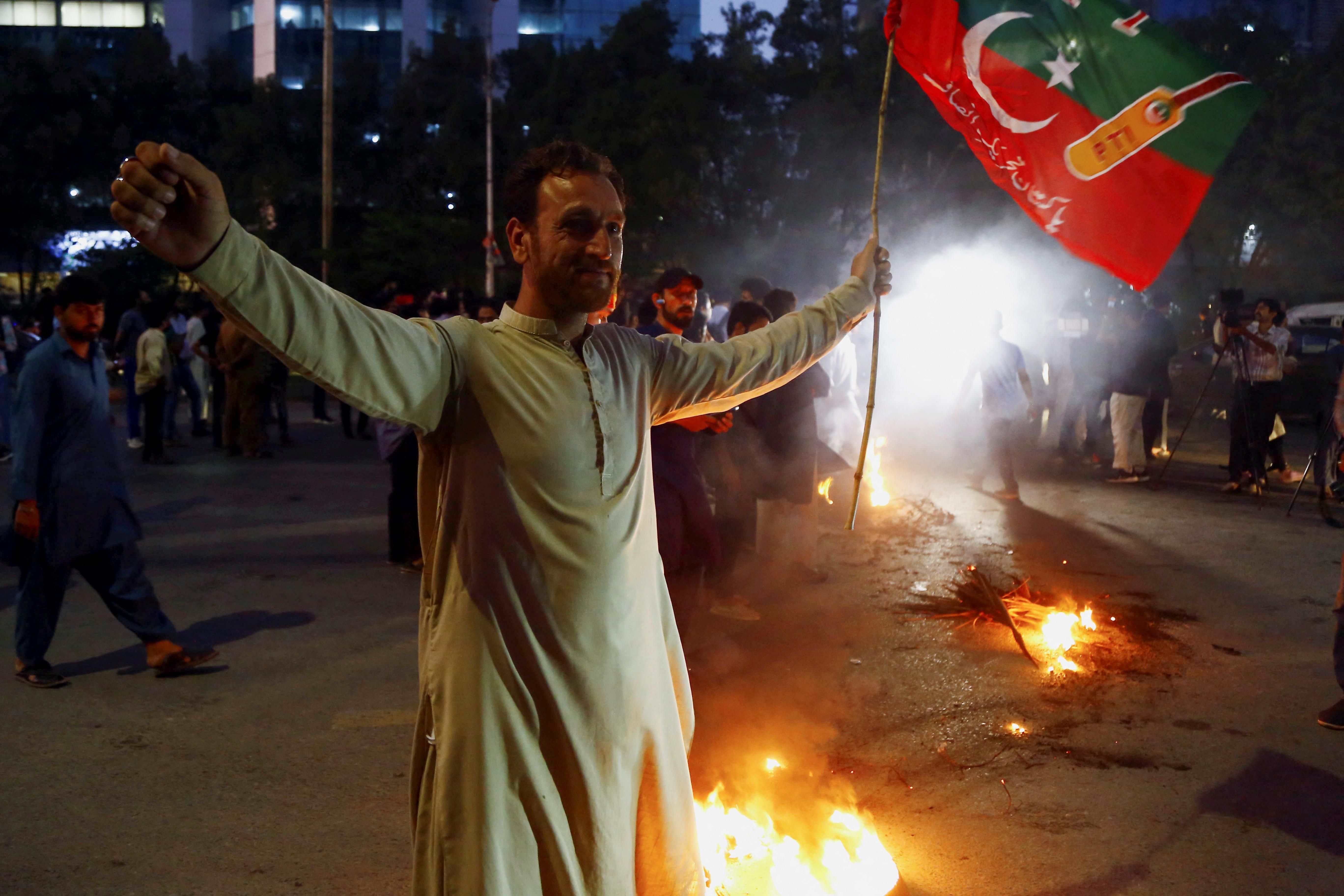 A supporter of Pakistan's former PM Imran Khan in Karachi gestures following the shooting incident on his long march in Wazirabad. 
