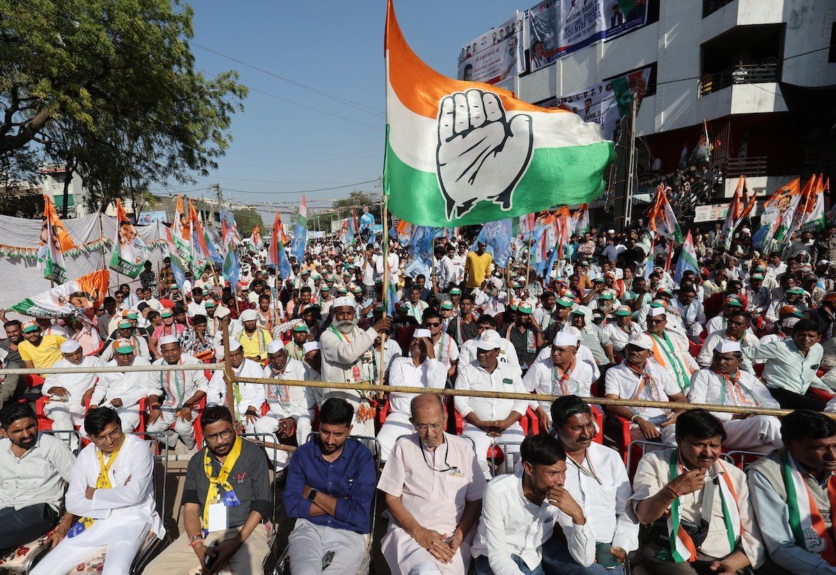 ​A supporter of Rahul Gandhi, a senior leader of India's main opposition Congress party, waves a party flag in a public meeting during Rahul's 66-day long "Bharat Jodo Nyay Yatra," or Unite India Justice March, in Jhalod town, Gujarat state, India, in March 2024. 