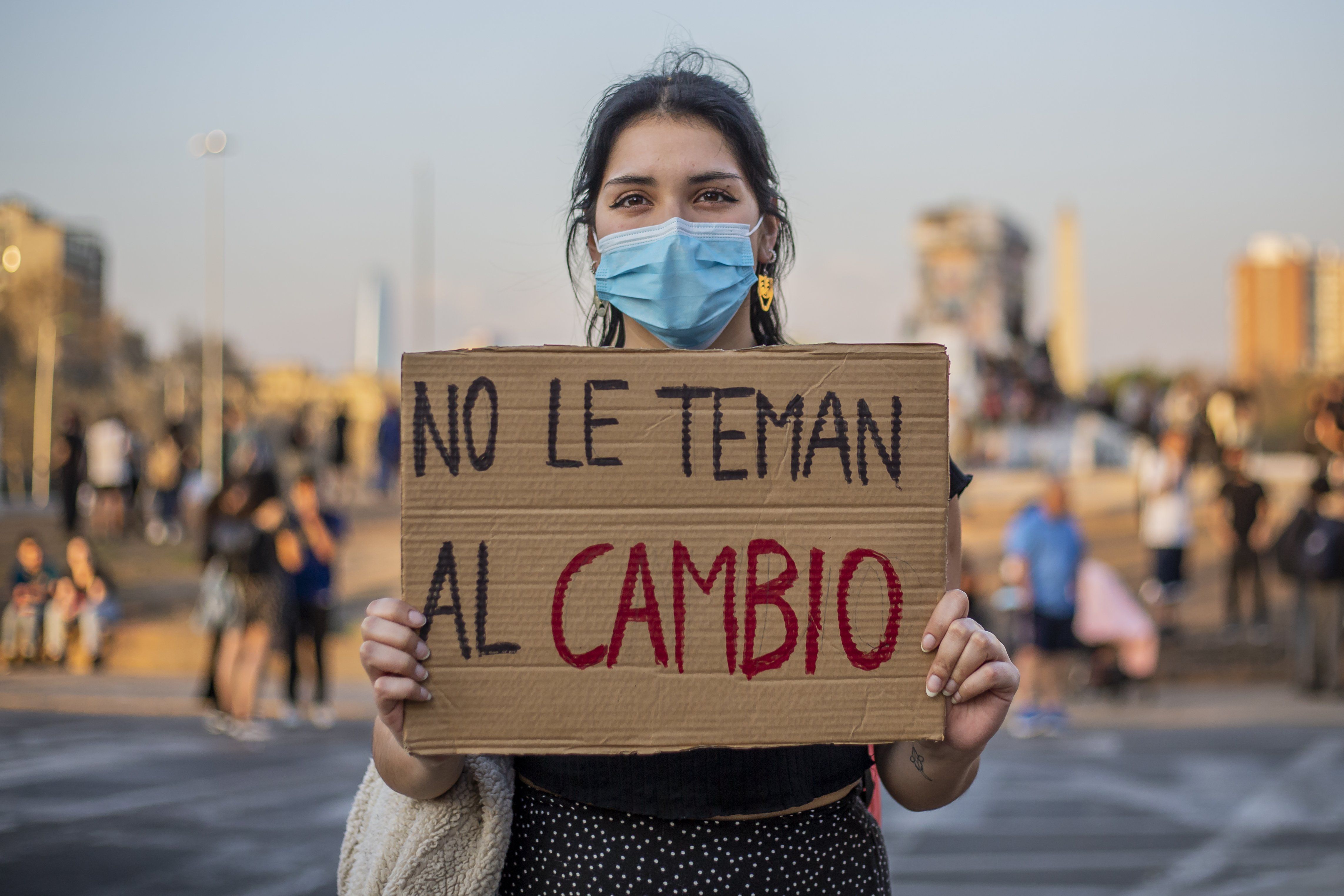 A woman holds a sign with the phrase "Don't be afraid of change" following the constitutional referendum in Santiago de Chile.