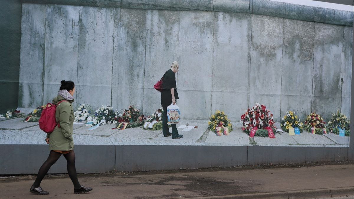 ​A woman walks past the Belfast peace wall on September 30, 2019.
