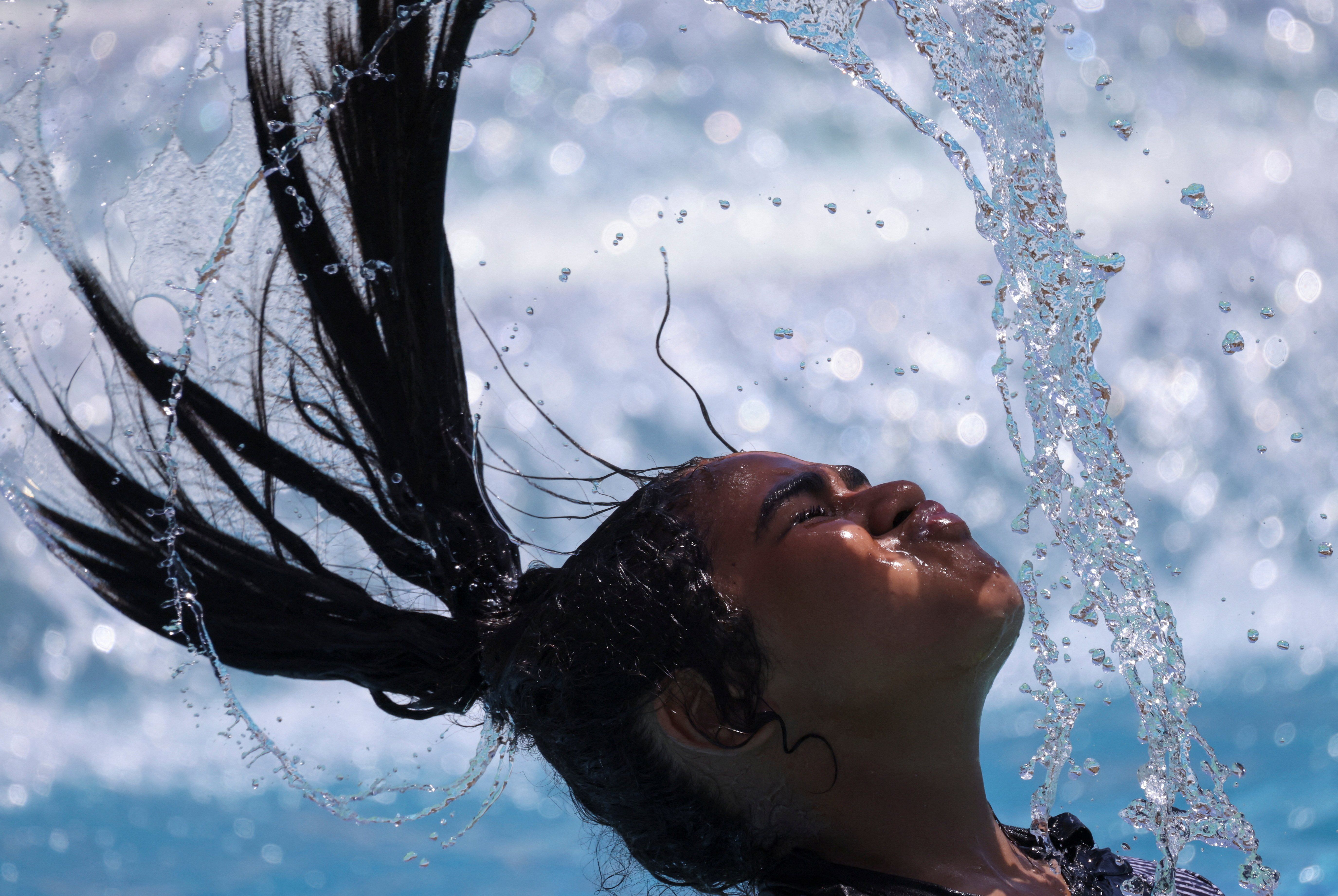 An Egyptian girl whips her wet hair while cooling off in the water amid a heatwave in Hurghada, Egypt.